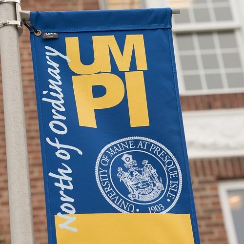 Photo of UMPI banner outside a campus building.