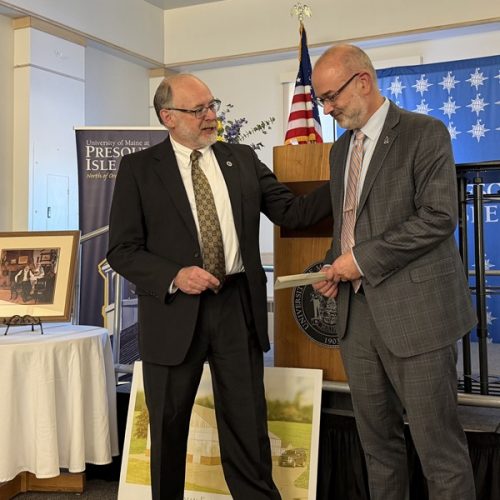 Photo of Jim Munch presenting a check for $2.1 million to UMPI President Ray Rice in the Campus Center MPR.
