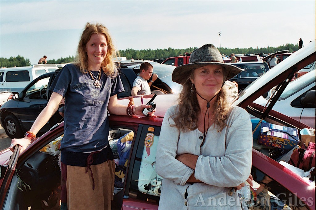 two fans next to their car