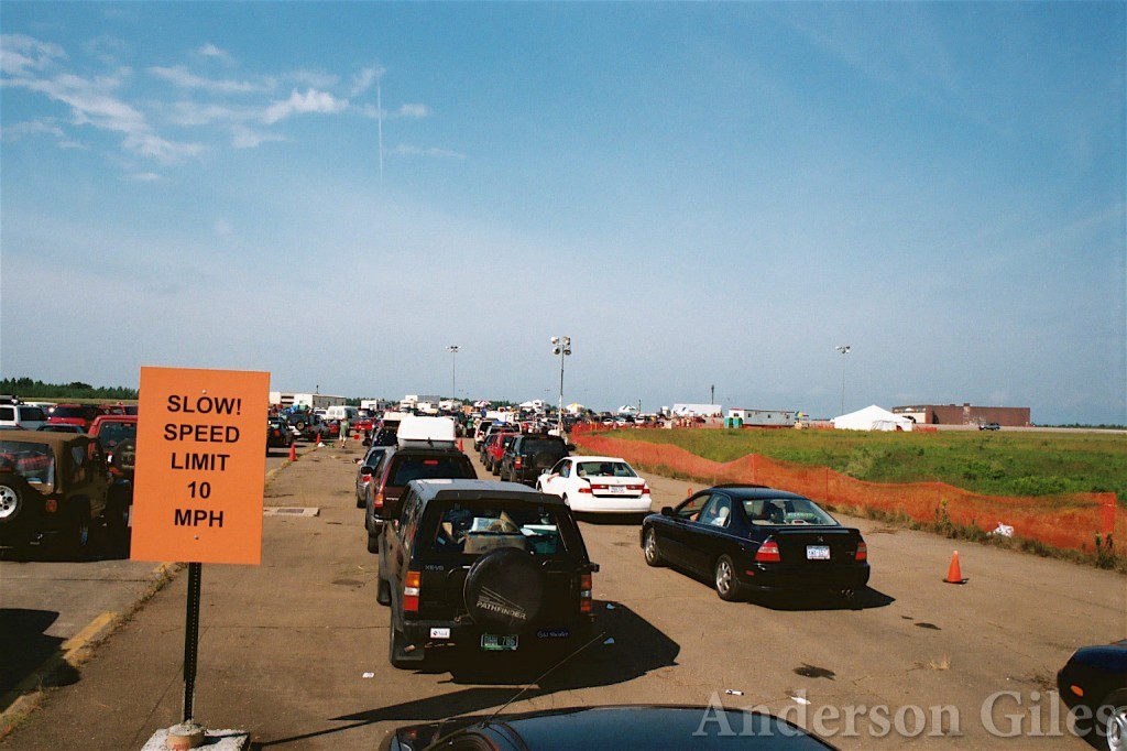 long line of cars with sign in the foreground: "Slow! Speed Limit 10mph"