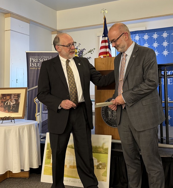 Photo of Jim Munch presenting a check for $2.1 million to UMPI President Ray Rice in the Campus Center MPR.